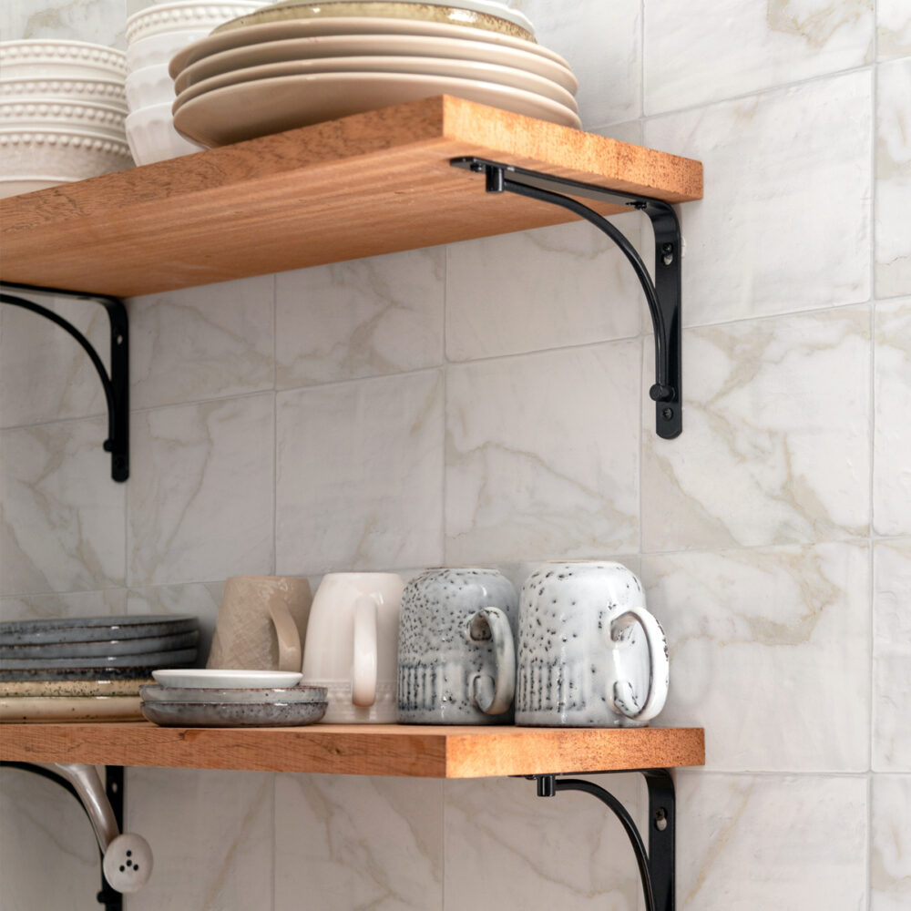 A kitchen with two shelves and some plates on them