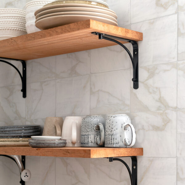 A kitchen with two shelves and some plates on them