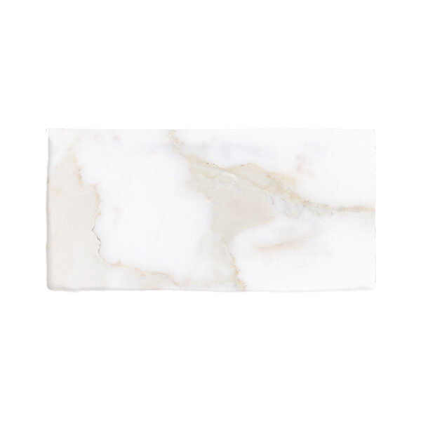 A white marble tile with some brown spots on it