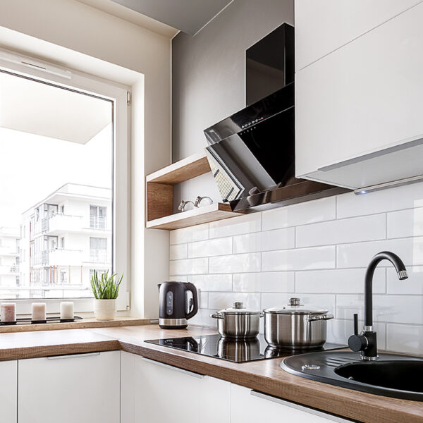 A kitchen with white cabinets and black appliances.