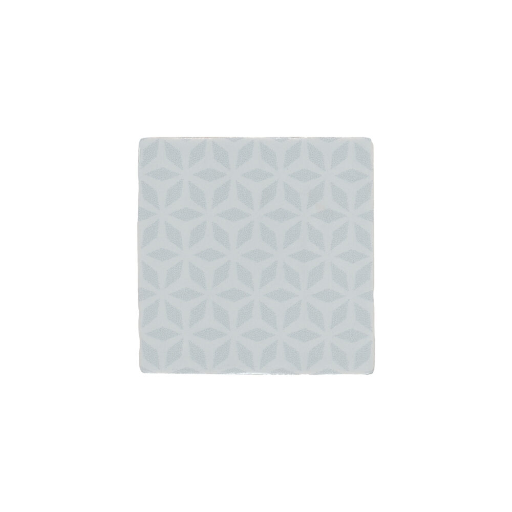 A white tile with a pattern of flowers.