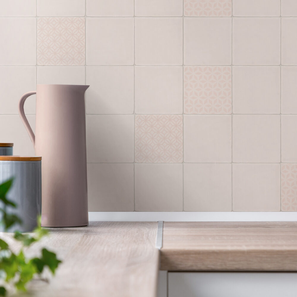 A white tile wall with a pitcher and a plant.