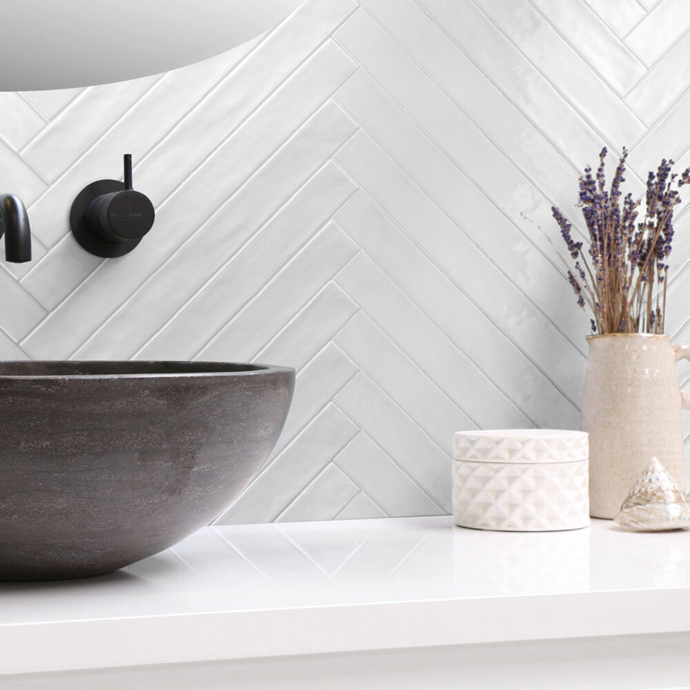 A bathroom sink and vase on the counter.