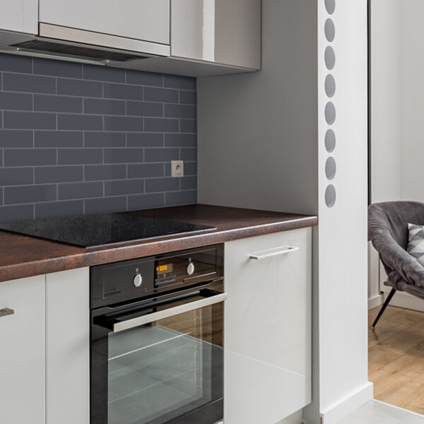 A kitchen with white cabinets and black oven.