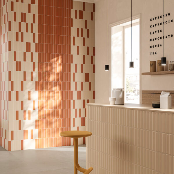 A room with a yellow stool and a wall of orange tiles.