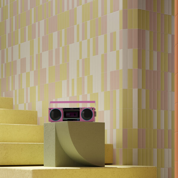 A pink boombox sitting on top of a wooden block.