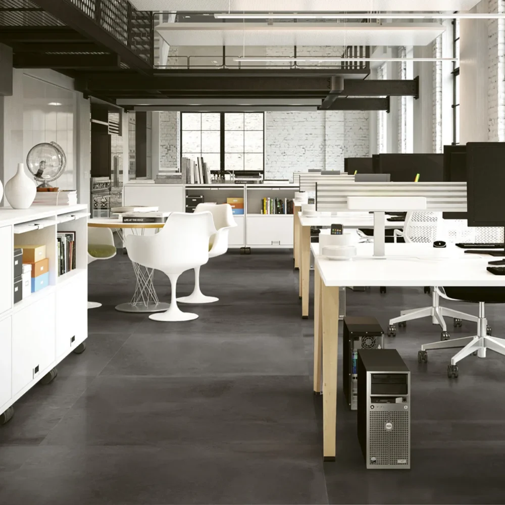 A large open office space with many tables and chairs.